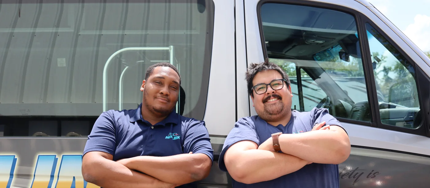 Two ACC Medlink crew members standing beside a transport van